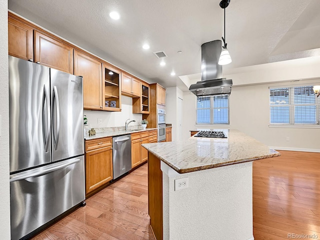 kitchen with light stone counters, light wood-style flooring, appliances with stainless steel finishes, and island exhaust hood