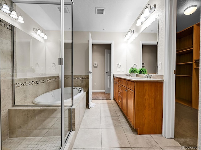 full bathroom featuring tile patterned flooring, visible vents, a bath, and double vanity