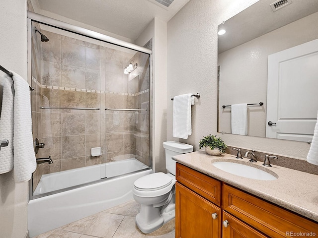 bathroom with vanity, visible vents, shower / bath combination with glass door, tile patterned flooring, and toilet