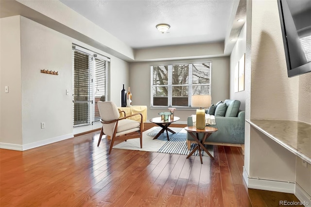 sitting room with baseboards and wood finished floors