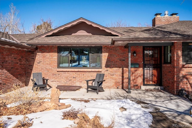 snow covered property featuring a patio area