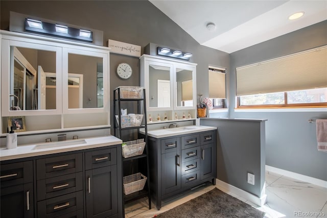 9400 E Iliff Ave Unit 411, Denver, CO 80231 - bathroom with baseboards, marble finish floor, vanity, and vaulted ceiling