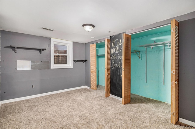 unfurnished bedroom with light carpet and two closets