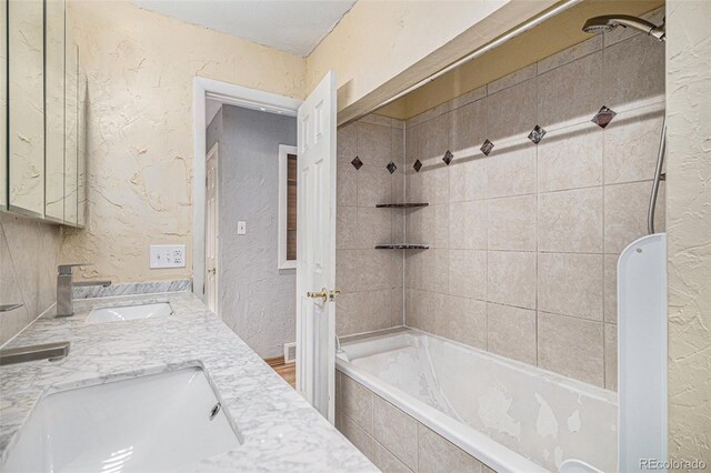 bathroom featuring vanity and tiled shower / bath