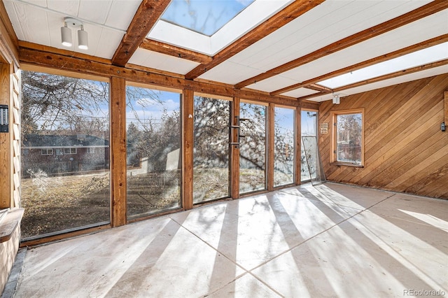 unfurnished sunroom featuring beam ceiling