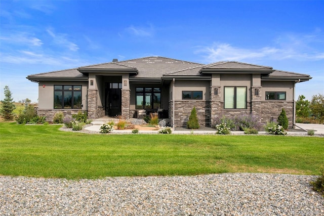 view of front facade featuring stone siding, a front lawn, and stucco siding