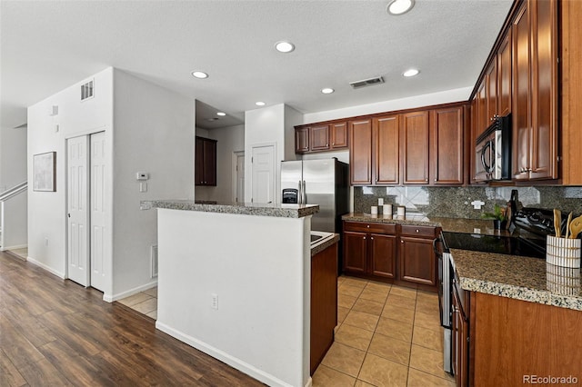 13020 Grant Cir W Unit A, Thornton, CO 80241 - kitchen featuring appliances with stainless steel finishes, decorative backsplash, recessed lighting, stone counters, and baseboards