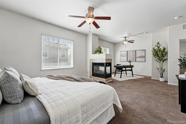 13020 Grant Cir W Unit A, Thornton, CO 80241 - bedroom with dark colored carpet, a tiled fireplace, baseboards, and ceiling fan