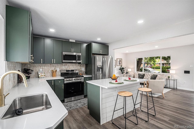 530 Everett St, Lakewood, CO 80226 - kitchen with stainless steel appliances, a breakfast bar, light countertops, backsplash, and dark wood finished floors