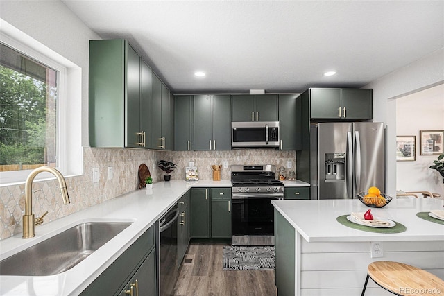 530 Everett St, Lakewood, CO 80226 - kitchen with stainless steel appliances, light countertops, dark wood-style flooring, tasteful backsplash, and recessed lighting