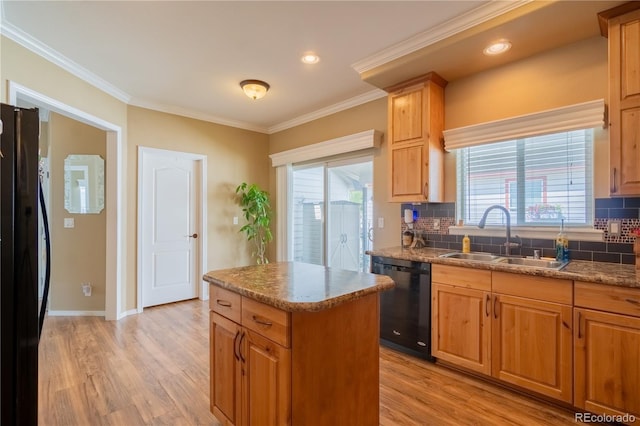 7885 Buckhorn Grn Unit 131, Frederick, CO 80530 - kitchen featuring black appliances, decorative backsplash, light wood finished floors, a center island, and ornamental molding