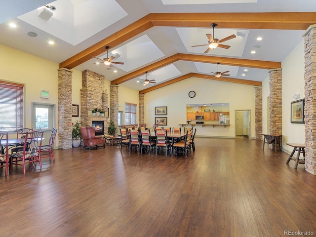7885 Buckhorn Grn Unit 131, Frederick, CO 80530 - dining area with a ceiling fan, a stone fireplace, wood finished floors, high vaulted ceiling, and beam ceiling