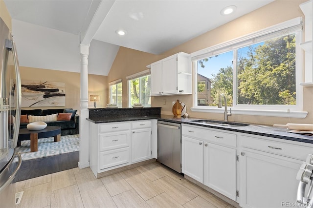 2640 Overlook Dr, Broomfield, CO 80020 - kitchen with appliances with stainless steel finishes, a peninsula, vaulted ceiling, white cabinetry, and dark stone counters