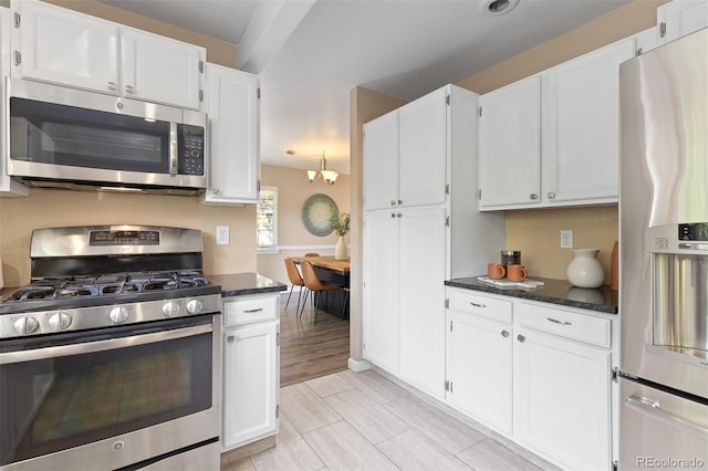 2640 Overlook Dr, Broomfield, CO 80020 - kitchen featuring appliances with stainless steel finishes, white cabinets, dark stone counters, and a chandelier