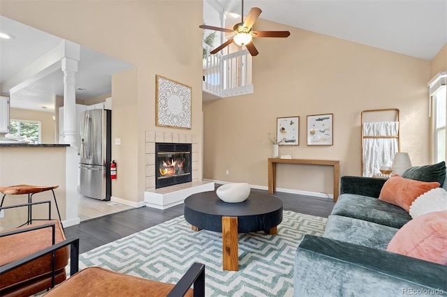 2640 Overlook Dr, Broomfield, CO 80020 - living room with decorative columns, ceiling fan, high vaulted ceiling, wood finished floors, and a tiled fireplace
