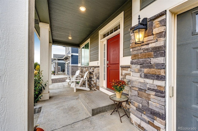 doorway to property featuring covered porch and stone siding