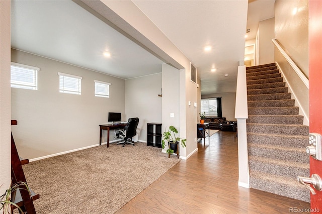 home office featuring a healthy amount of sunlight, visible vents, baseboards, and wood finished floors