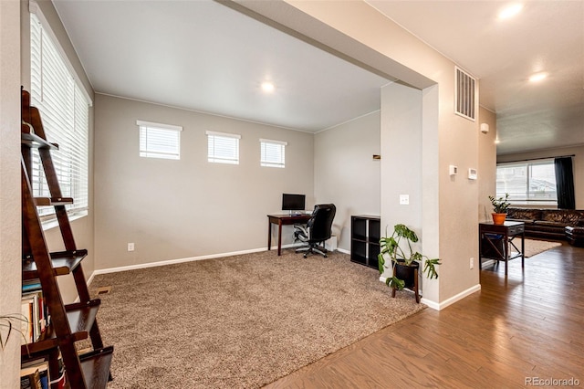 office area with carpet, visible vents, baseboards, and wood finished floors