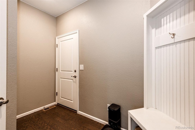 mudroom with a textured wall, dark wood finished floors, visible vents, and baseboards