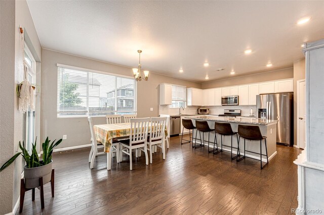 dining area with a toaster, recessed lighting, dark wood-type flooring, baseboards, and an inviting chandelier