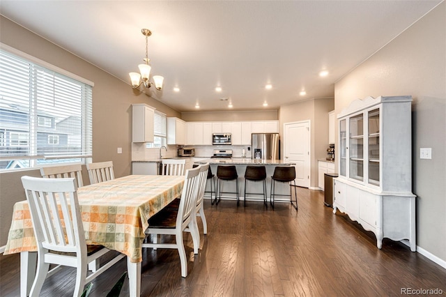 dining room featuring recessed lighting, dark wood finished floors, baseboards, and an inviting chandelier