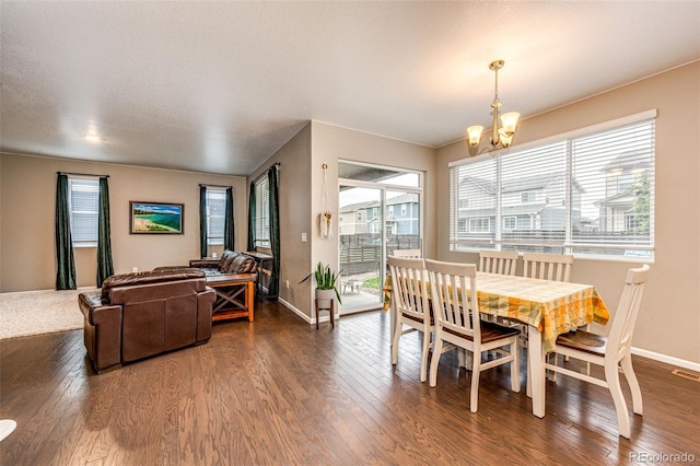 dining room featuring a chandelier, visible vents, baseboards, and wood finished floors