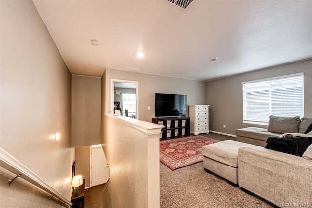 living room featuring dark carpet, visible vents, and baseboards