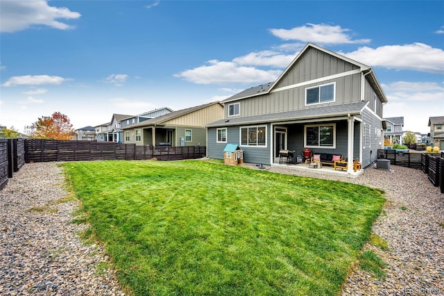 back of house featuring board and batten siding, a patio area, a fenced backyard, and a lawn