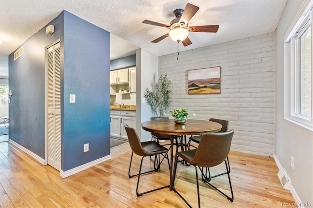 1060 S Parker Rd Unit 25, Denver, CO 80231 - dining space featuring a textured ceiling, a ceiling fan, light wood-type flooring, and plenty of natural light