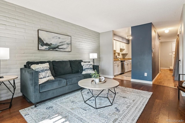 1060 S Parker Rd Unit 25, Denver, CO 80231 - living room with dark wood finished floors, an accent wall, and brick wall