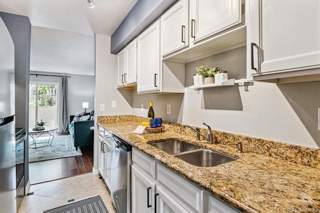 1060 S Parker Rd Unit 25, Denver, CO 80231 - kitchen featuring dishwasher, white cabinetry, light stone countertops, light tile patterned floors, and arched walkways