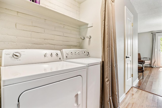 1060 S Parker Rd Unit 25, Denver, CO 80231 - laundry room featuring hardwood / wood-style floors, washing machine and clothes dryer, and a textured ceiling