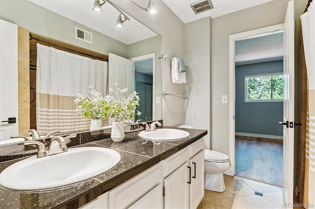 1060 S Parker Rd Unit 25, Denver, CO 80231 - bathroom featuring double vanity, tile patterned floors, and a shower with shower curtain