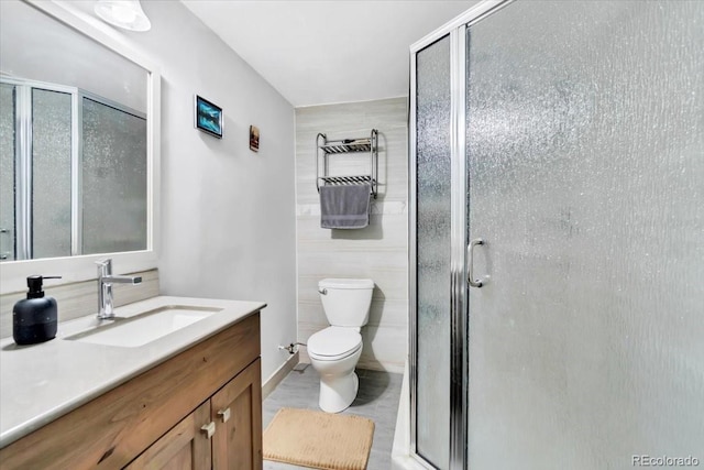 full bath with vanity, toilet, and a stall shower