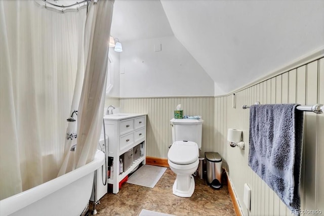 full bathroom featuring toilet, vanity, wainscoting, lofted ceiling, and shower / tub combo with curtain