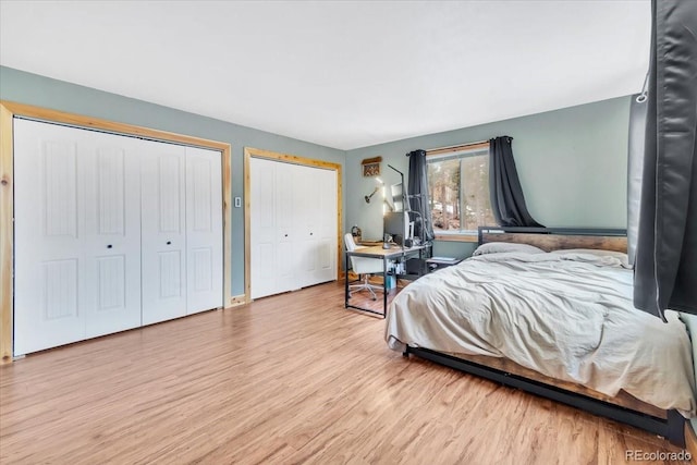 bedroom with two closets and light wood-style floors