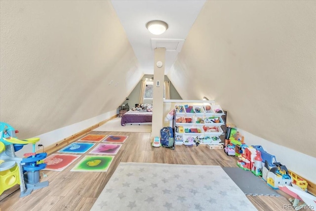 rec room with wood finished floors and lofted ceiling