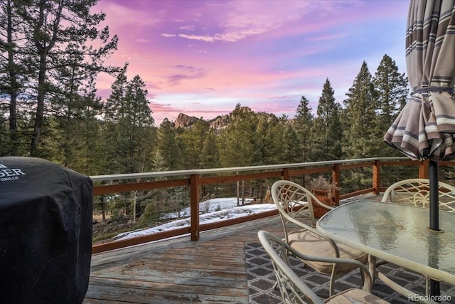 snow covered deck with grilling area and outdoor dining space