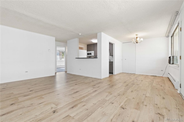 10185 W 25th Ave Unit 33, Lakewood, CO 80215 - unfurnished living room featuring light wood-style floors, a chandelier, baseboard heating, and a textured ceiling