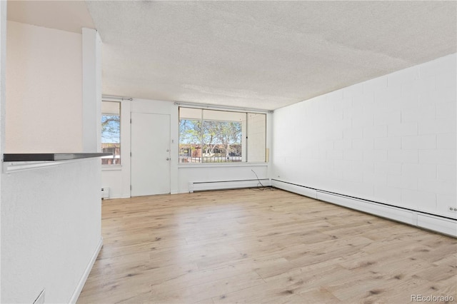 10185 W 25th Ave Unit 33, Lakewood, CO 80215 - spare room featuring wood finished floors, a textured ceiling, baseboard heating, a baseboard heating unit, and concrete block wall
