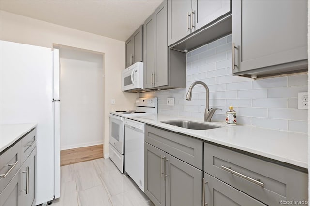 10185 W 25th Ave Unit 33, Lakewood, CO 80215 - kitchen with gray cabinetry, white appliances, a sink, backsplash, and light countertops