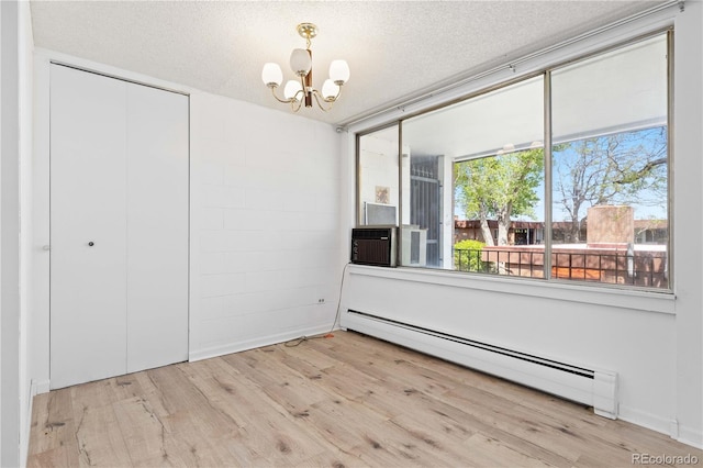 10185 W 25th Ave Unit 33, Lakewood, CO 80215 - unfurnished dining area featuring a baseboard heating unit, a chandelier, wood finished floors, a textured ceiling, and cooling unit