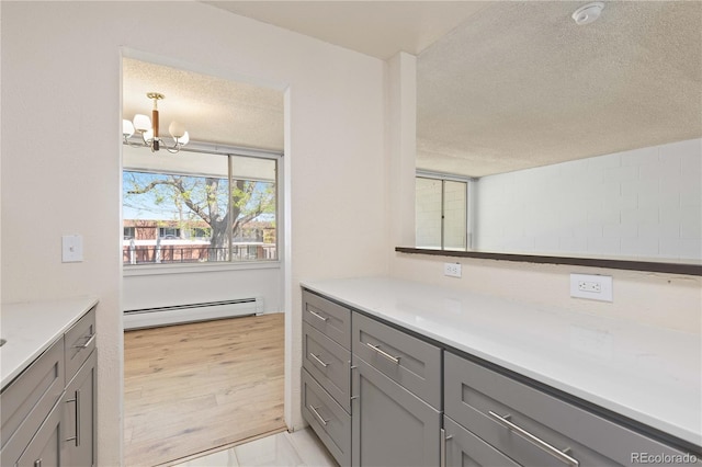 10185 W 25th Ave Unit 33, Lakewood, CO 80215 - bathroom featuring a baseboard heating unit, a textured ceiling, a chandelier, and vanity