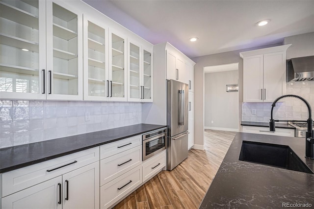 kitchen featuring a sink, stainless steel appliances, light wood-style flooring, and white cabinetry