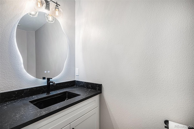 bathroom with vanity and a textured wall