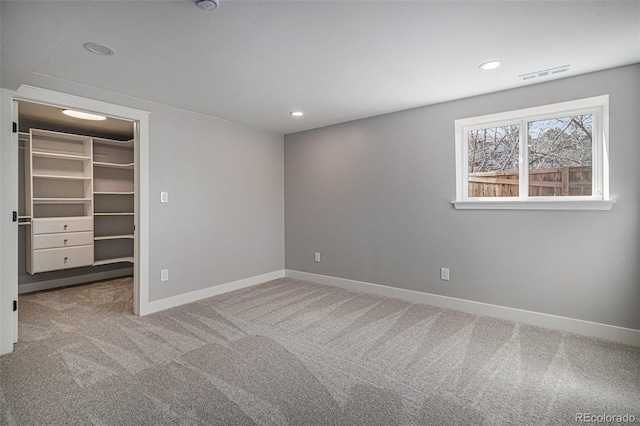 unfurnished bedroom with visible vents, recessed lighting, carpet, baseboards, and a spacious closet