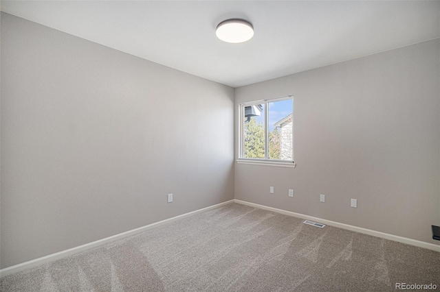 carpeted empty room featuring visible vents and baseboards