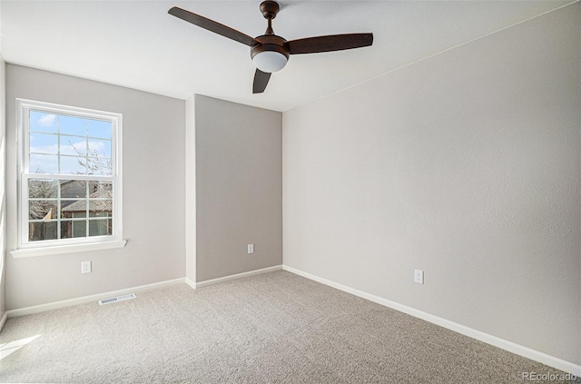 carpeted empty room featuring baseboards, visible vents, and ceiling fan