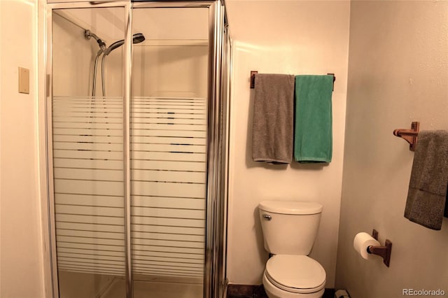 bathroom featuring a stall shower and toilet