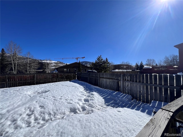 yard covered in snow with a fenced backyard